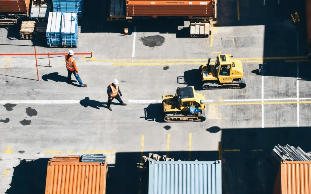 Aerial view of a modern construction site with on-site storage containers and workers organizing tools.